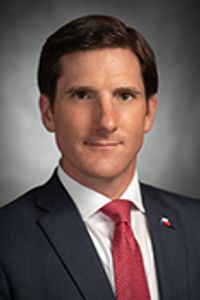 This is a photo of Brooks Landgraf (Republican Party) is a member of the Texas House of Representatives, representing District 81. wearing a red tie and black jacket.