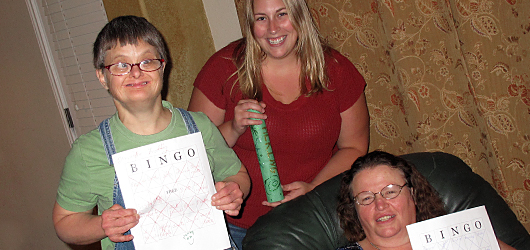 Three women holding bingo cards
